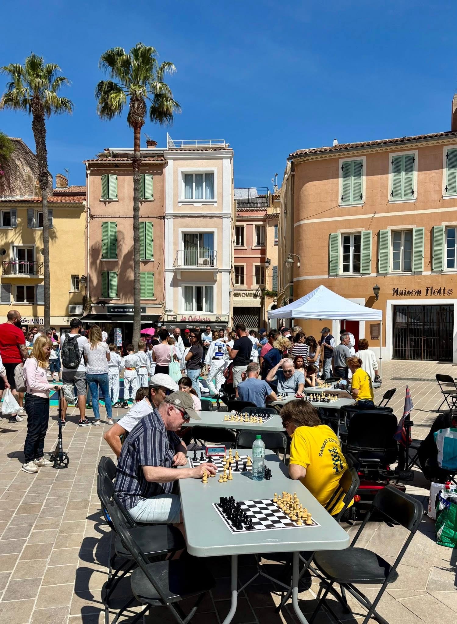 Travelers enjoy outdoor chess in a sunny Italian or Croatian town square during an Adventures for Solo Travelers luxury sailing cruise on Windstar's Wind Surf, the largest sailboat in the world.