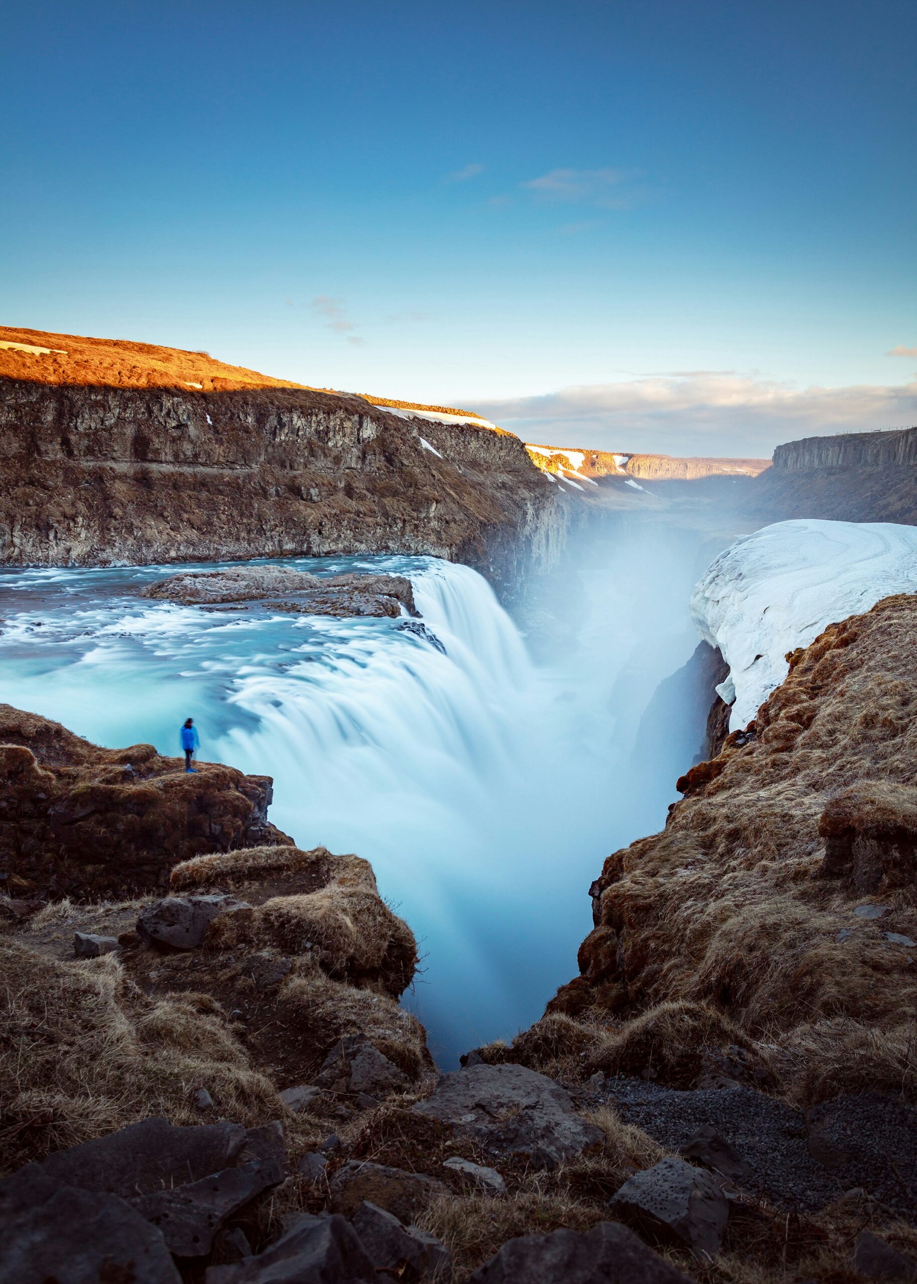 Gullfoss Waterfall in Iceland cascades into a rugged canyon as a solo traveler overlooks the falls during a guided small group adventure tour for travelers age 45+.