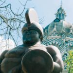 Fernando Botero sculpture in Plaza Botero with the Palacio de la Cultura in Medellín, Colombia, visited on the Adventures for Solo Travelers Colorful Colombia small group tour for travelers age 45 and over.